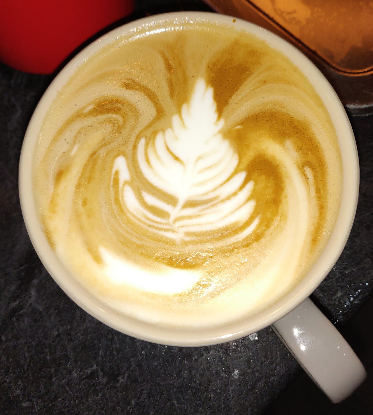 Cup of coffee with latte art on a dark surface
