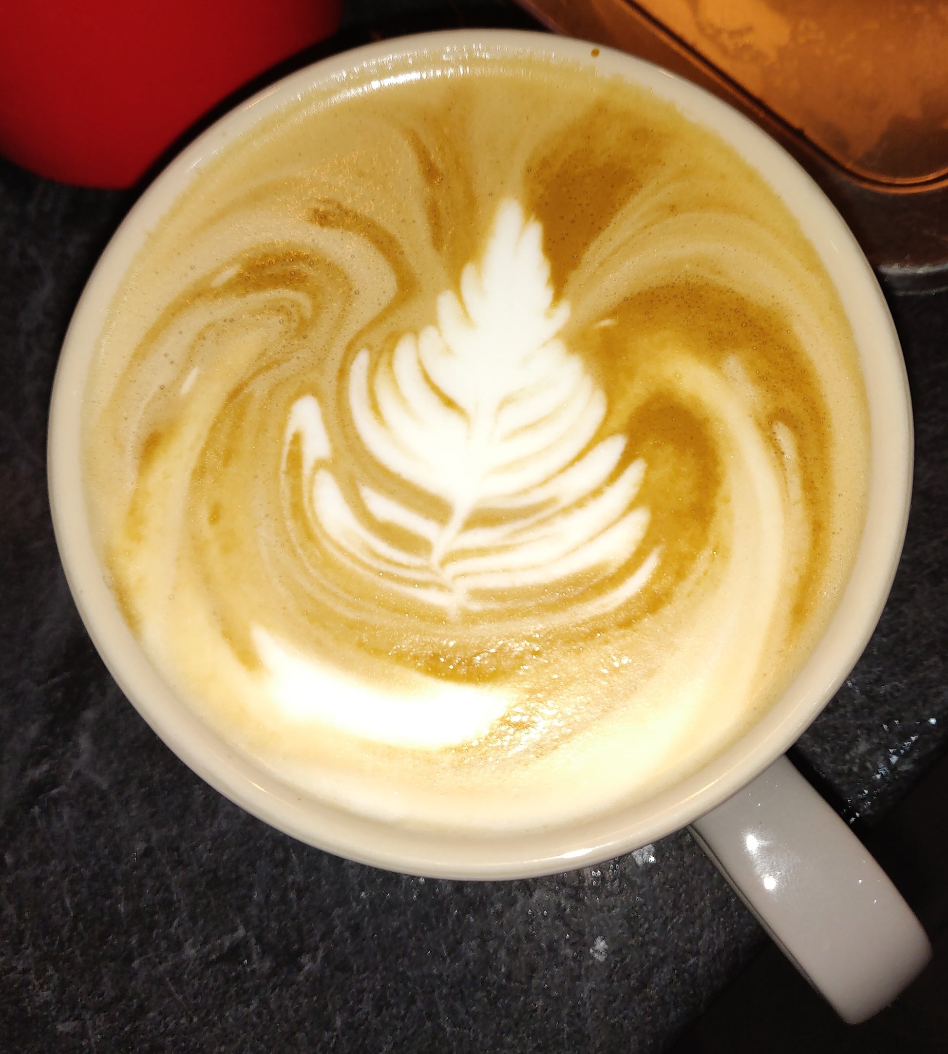 Cup of coffee with latte art on a dark surface
