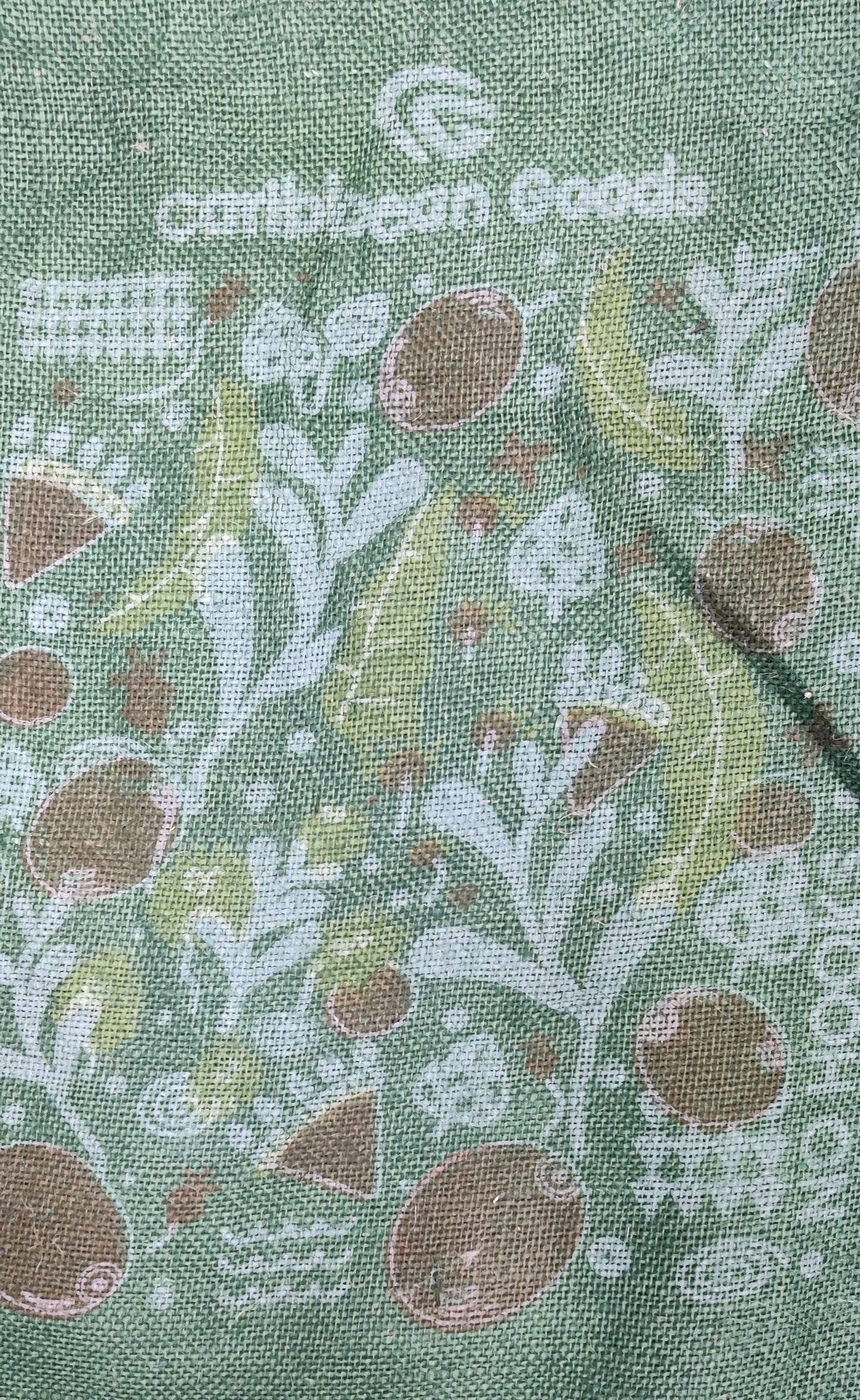 Green coffee sack with abstract printed design of coffee beans, trees and leaves