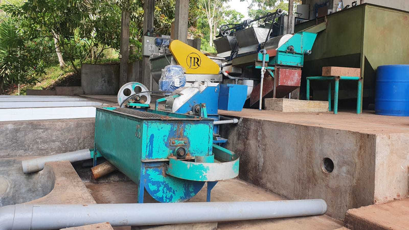 Outdoor setting with a blue machine labeled 'JR' and various equipment on a concrete platform.